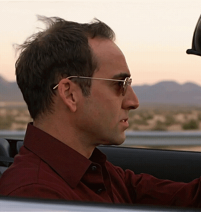 Man In Red Shirt And Sunglasses Driving Car GIF