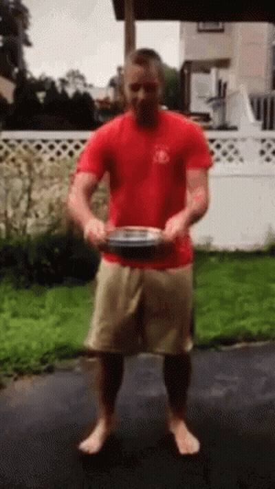 Man In Red Shirt And Tan Shorts Holding Plate GIF