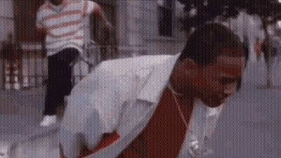 Man In Red Shirt And White Jacket On Sidewalk GIF
