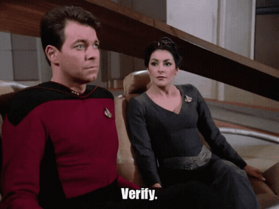 Man In Red Shirt And Woman In Black Dress Saying Verify GIF