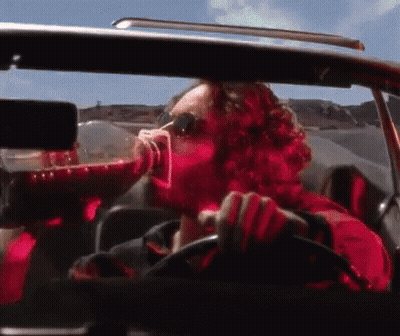 Man In Red Shirt Drinking While Driving GIF