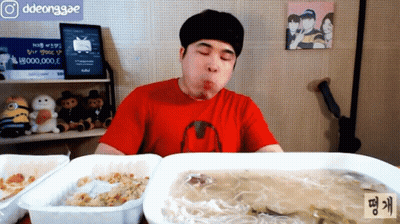 Man In Red Shirt Eating Meal With Ddeonggae Sign GIF