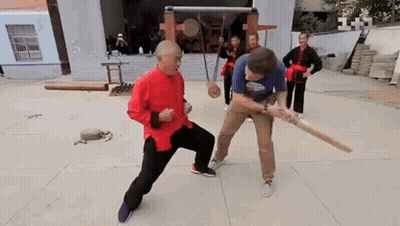 Man In Red Shirt Fighting With Wooden Bat GIF