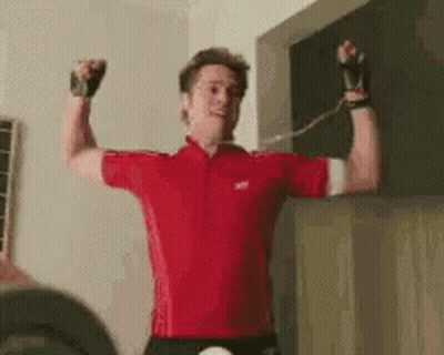 Man In Red Shirt Flexing Muscles Holding Rope GIF