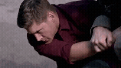 Man In Red Shirt Holding Another Man's Arm On Ground GIF