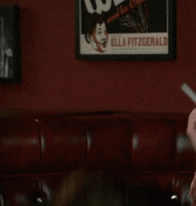 Man In Red Shirt Holding Knife In Mouth GIF