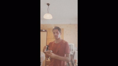 Man In Red Shirt Holding Something GIF