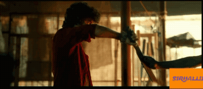 Man In Red Shirt Holding Sword In Front Of Sirijalli Sign GIF