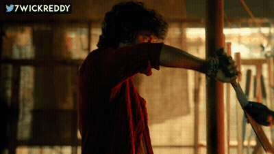 Man In Red Shirt Holding Sword In Front Of Twitter Logo GIF