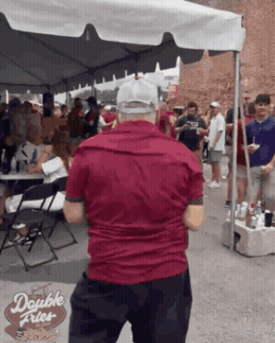 Man In Red Shirt In Front Of Double Fries Tent GIF