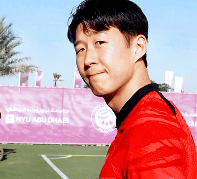 Man In Red Shirt In Front Of NYU Abu Dhabi GIF
