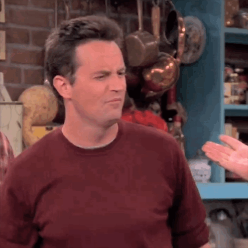 Man In Red Shirt In Front Of Shelf With Pots And Pans GIF