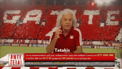 Man In Red Shirt In Front Of Tatakis Banner GIF