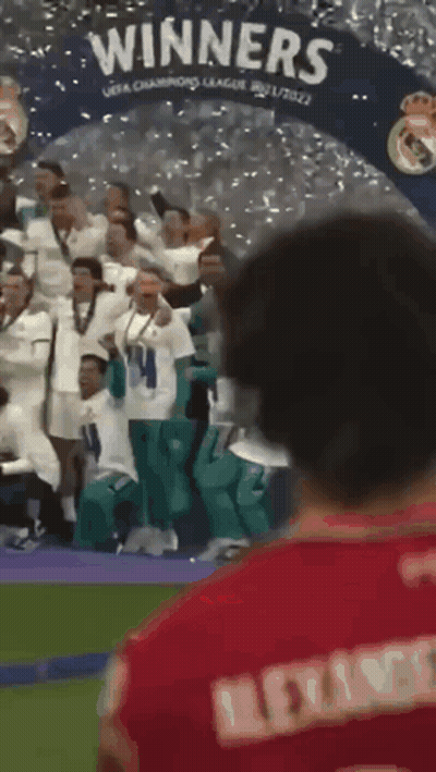 Man In Red Shirt In Front Of Winners Banner GIF