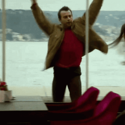 Man In Red Shirt Jumping Arms Out GIF