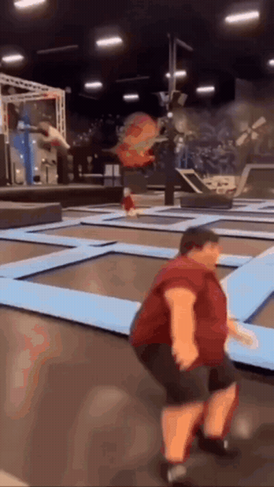 Man In Red Shirt Jumping On Trampoline GIF