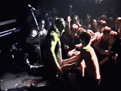 Man In Red Shirt Kneeling Before Crowd GIF