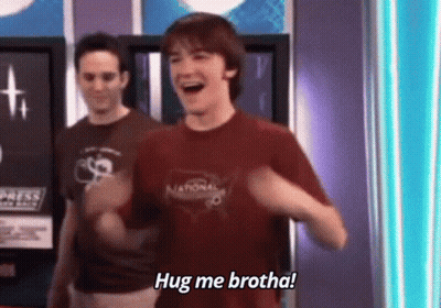 Man In Red Shirt Laughing Saying Hug Me Brotha Next To Another Man GIF