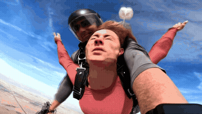 Man In Red Shirt Lifted By Man In Black Helmet GIF