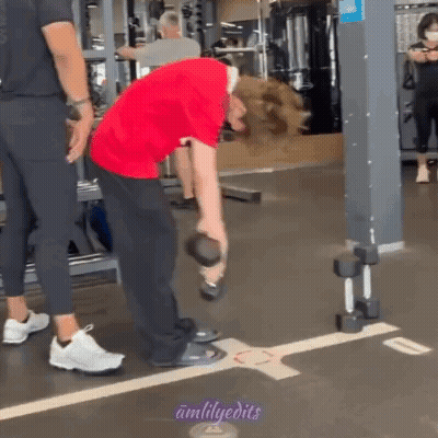 Man In Red Shirt Lifting Dumbbell While Another Man Watches GIF