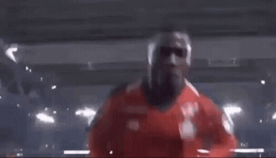Man In Red Shirt Making Funny Face In Dark Room GIF