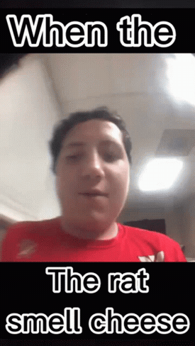 Man In Red Shirt Making Funny Face When Rat Smells Cheese GIF