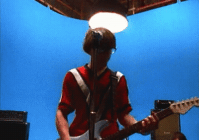 Man In Red Shirt Playing Guitar At Microphone GIF
