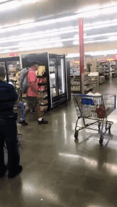 Man In Red Shirt Pushing Shopping Cart GIF