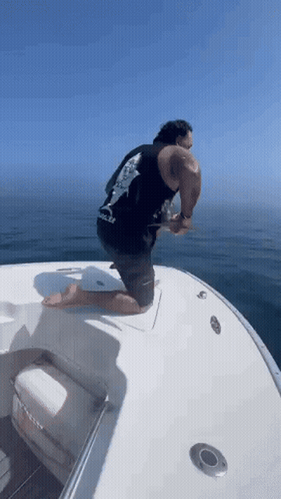 Man In Red Shirt Riding Boat Saying Triathlon GIF