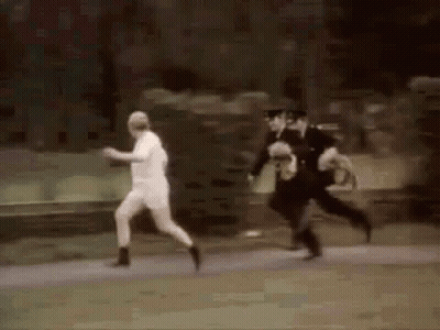 Man In Red Shirt Running Down Road GIF