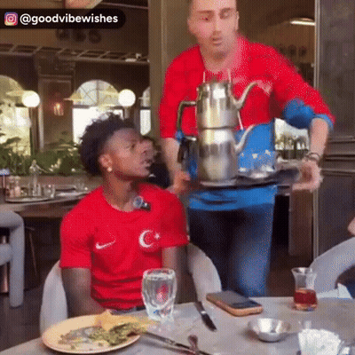 Man In Red Shirt Sitting At Table GIF