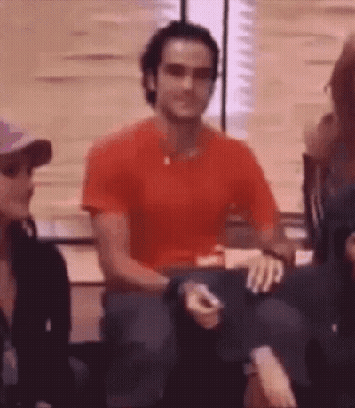 Man In Red Shirt Sitting In Chair Holding Cigarette GIF