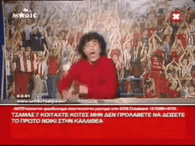 Man In Red Shirt Sitting In Front Of Crowd GIF