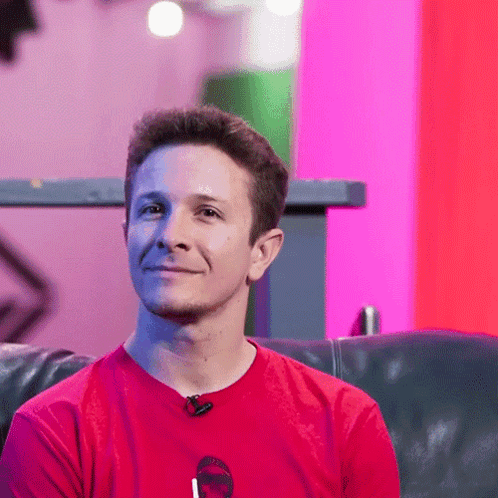 Man In Red Shirt Sitting On Black Couch GIF