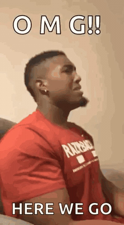 Man In Red Shirt Sitting On Couch Making Face GIF