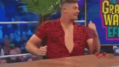 Man In Red Shirt Sitting With Shirt Open GIF