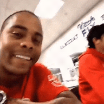 Man In Red Shirt Smiling At Table GIF
