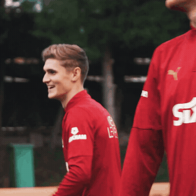 Man In Red Shirt Smiling With Dam On Sleeve GIF