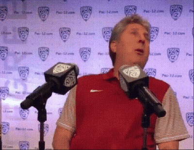 Man In Red Shirt Speaking Into Microphones GIF