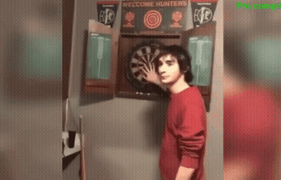 Man In Red Shirt Standing Before Dart Board GIF