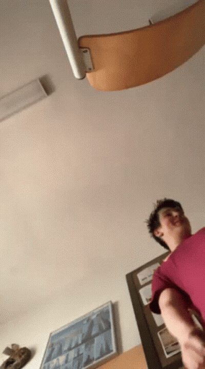 Man In Red Shirt Standing By Staircase GIF