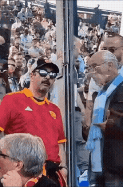 Man In Red Shirt Standing In Crowd GIF