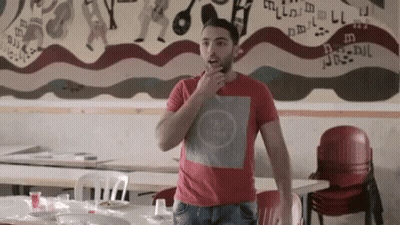 Man In Red Shirt Standing In Front Of Mural GIF