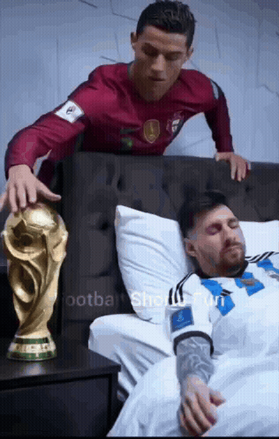 Man In Red Shirt Standing Next To Man In White Shirt In Bed GIF
