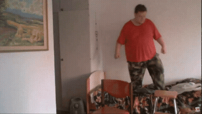 Man In Red Shirt Standing On Chair GIF