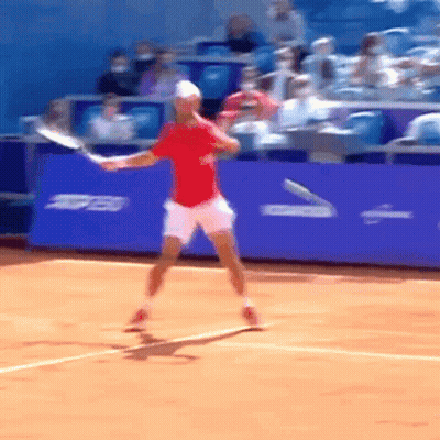 Man In Red Shirt Swinging Tennis Racquet On Court GIF