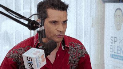 Man In Red Shirt Talking Into Microphone With Sim Box GIF