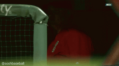 Man In Red Shirt Talking On Phone In Dugout GIF