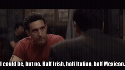 Man In Red Shirt Talking To Another In Dark Room GIF