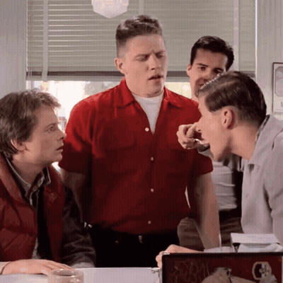 Man In Red Shirt Talking To Man In White Shirt GIF
